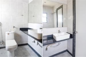 a bathroom with a sink and a toilet and a mirror at FabHotel Krishna Regency in Pune