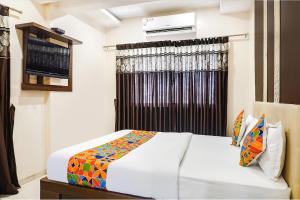 a hotel room with a bed and a window at FabHotel Krishna Regency in Pune