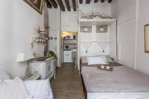 a small room with two beds and a kitchen at La Belle Du Marais in Paris