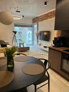 a kitchen and living room with a table and chairs at Apartament G13 Nautica Resort Giżycko in Giżycko