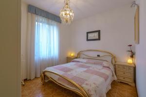 a bedroom with a bed and a chandelier at Villetta Maurizia in Domaso