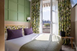 - une chambre avec un grand lit et une fenêtre dans l'établissement Hotel Clément, à Paris