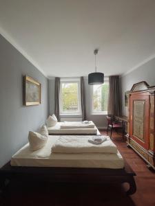 2 camas en una habitación con 2 ventanas en Apartments im Herzen Lübecks en Lübeck