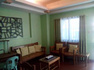 a living room with chairs and a couch and a table at Gomez Guest House in Tagbilaran City