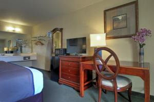 a hotel room with a desk with a television and a bed at Key West Inn - Tunica Resort in Tunica Resorts
