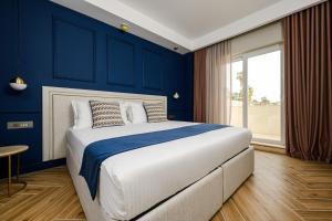 ein Schlafzimmer mit blauen Wänden und einem großen Bett in der Unterkunft XVI Suites - Adults Only in Naxxar
