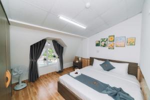 um quarto com uma cama e uma janela em AN TÂM House Đà Lạt em Da Lat