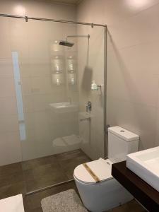 a bathroom with a toilet and a glass shower at Leena Holiday Home in Batticaloa