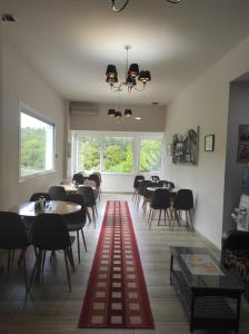 a dining room with tables and chairs and windows at Ενοικιαζόμενα Δωμάτια Ενιπεύς- Rooms Enipeas in Litochoro