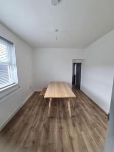 una habitación con una mesa de madera en el medio de una habitación en Newly Renovated Coastal Property, en Llanelli