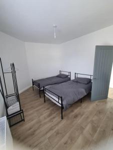 Habitación con 2 camas y suelo de madera. en Newly Renovated Coastal Property, en Llanelli