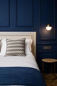 - une chambre bleue dotée d'un lit avec un oreiller et une table dans l'établissement XVI Suites - Adults Only, à Naxxar