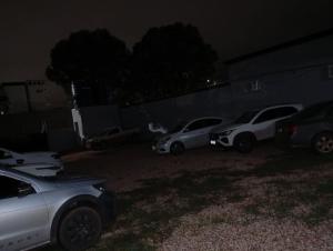 a group of cars parked in a yard at night at Hotel CNP Brasil in Campo Novo do Parecis