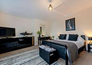 a bedroom with a bed and a flat screen tv at Harbour Lodge - Teignmouth in Teignmouth