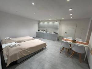 a bedroom with a bed and a desk and a kitchen at Pod Chmielową Szyszką in Chmielnik
