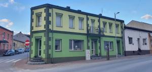 a green building on the corner of a street at Pod Chmielową Szyszką in Chmielnik