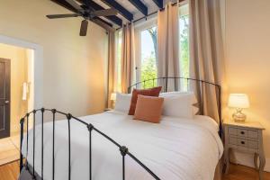 een slaapkamer met een bed met witte lakens en een raam bij European Influences in the Heart of Charleston in Charleston