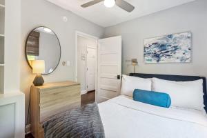 a bedroom with a large bed and a mirror at Freshly Renovated 2 Bedroom Apt Walk Everywhere in Charleston