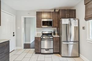 a kitchen with wooden cabinets and stainless steel appliances at Freshly Renovated 2 Bedroom Apt Walk Everywhere in Charleston