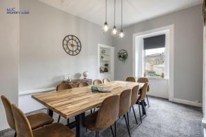 a dining room with a wooden table and chairs at Turret Town House in Hawick