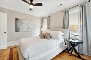 a white bedroom with a bed and a window at Downtown 3 Bedroom with Tons of Natural Light in Charleston