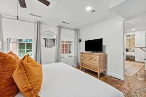a white bedroom with a bed and a television at Unique & Charming 2 Bedroom One Block to King St in Charleston