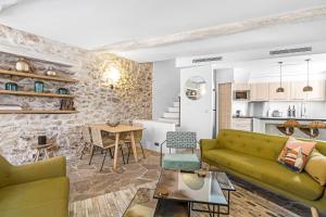 a living room with a green couch and a kitchen at Maison Misericorde in Saint-Tropez +14 photos