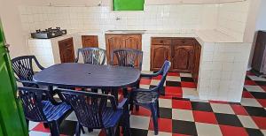 a table and chairs in a room with a kitchen at Maison les pieds dans l'eau (Ramena) in Andjamen