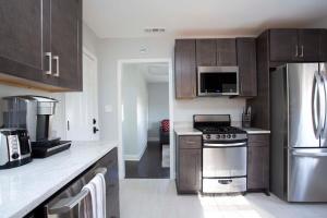 a kitchen with stainless steel appliances and wooden cabinets at Freshly Renovated 2 Bedroom Apt 1 Block to King in Charleston