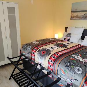 ein Schlafzimmer mit einem Bett mit einer bunten Bettdecke in der Unterkunft Ferienwohnung mit Wellness & Radverleih in Schwei