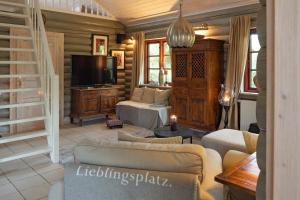 a living room with a couch and a television at Ferienhaus "Blokkhus am Ochsenweg" in Owschlag