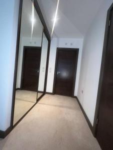 un couloir avec deux miroirs et deux portes dans l'établissement NDO DARTFORD LUXX PRIVATE ENSUITE-ROOM, à Dartford