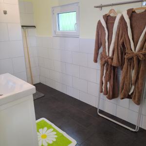 uma casa de banho com paredes em azulejos brancos e toalhas castanhas em Ferienwohnung mit Wellness & Radverleih em Schwei