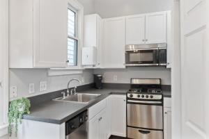 - une cuisine blanche avec évier et cuisinière dans l'établissement Spacious and Quiet One Block off King Street, à Charleston