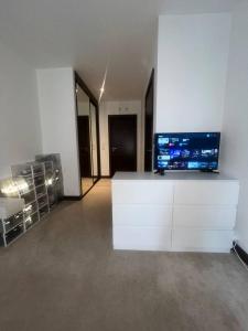NDO DARTFORD LUXX PRIVATE ENSUITE-ROOM في دارتفورد: غرفة معيشة مع خزانة بيضاء مع تلفزيون
