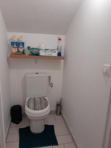 a bathroom with a toilet with a shelf on the wall at Appartement meublé à 30 minutes de Paris in Mantes-la-Jolie