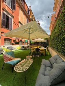 eine Terrasse mit einem Tisch, Stühlen und einem Sonnenschirm in der Unterkunft Free Hostels Roma in Rom