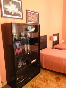 a room with a book shelf with glasses and a bed at Lo Studio del Pittore in Vasto