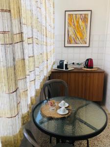 Una mesa de cristal en una habitación con escritorio y una mesa con sillas. en Lo Studio del Pittore, en Vasto