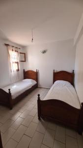 1 dormitorio con 2 camas y suelo de baldosa en saidia beach, en Saidia 