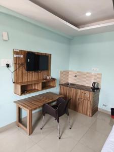 a room with a table and a chair and a television at HOTEL TIRATH in Rishīkesh