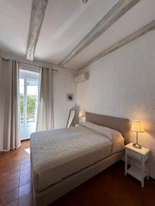 ein Schlafzimmer mit einem großen Bett und einem Fenster in der Unterkunft Hotel Maquis et Mer in Sari Solenzara