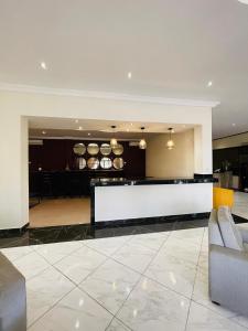 a lobby with a white counter and a kitchen at Niagara Hotel in Accra
