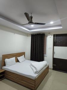 a bedroom with a bed with a ceiling fan at HOTEL TIRATH in Rishīkesh