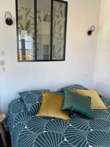 uma cama com duas almofadas e um espelho na parede em Le Ptit Duplex em Royan