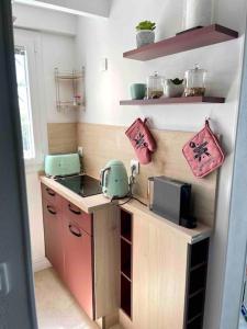 uma pequena cozinha com um balcão com um micro-ondas e um auscultador em Le Ptit Duplex em Royan