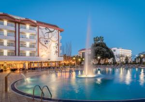 a fountain in a pool in front of a building at ALEGRIA Florida Park in Santa Susanna
