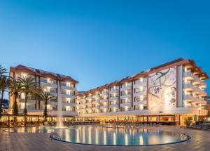 un hotel con piscina frente a un edificio en ALEGRIA Florida Park, en Santa Susanna