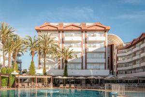 a hotel with a swimming pool and palm trees at ALEGRIA Florida Park in Santa Susanna