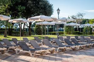 a row of lounge chairs and umbrellas at ALEGRIA Florida Park in Santa Susanna